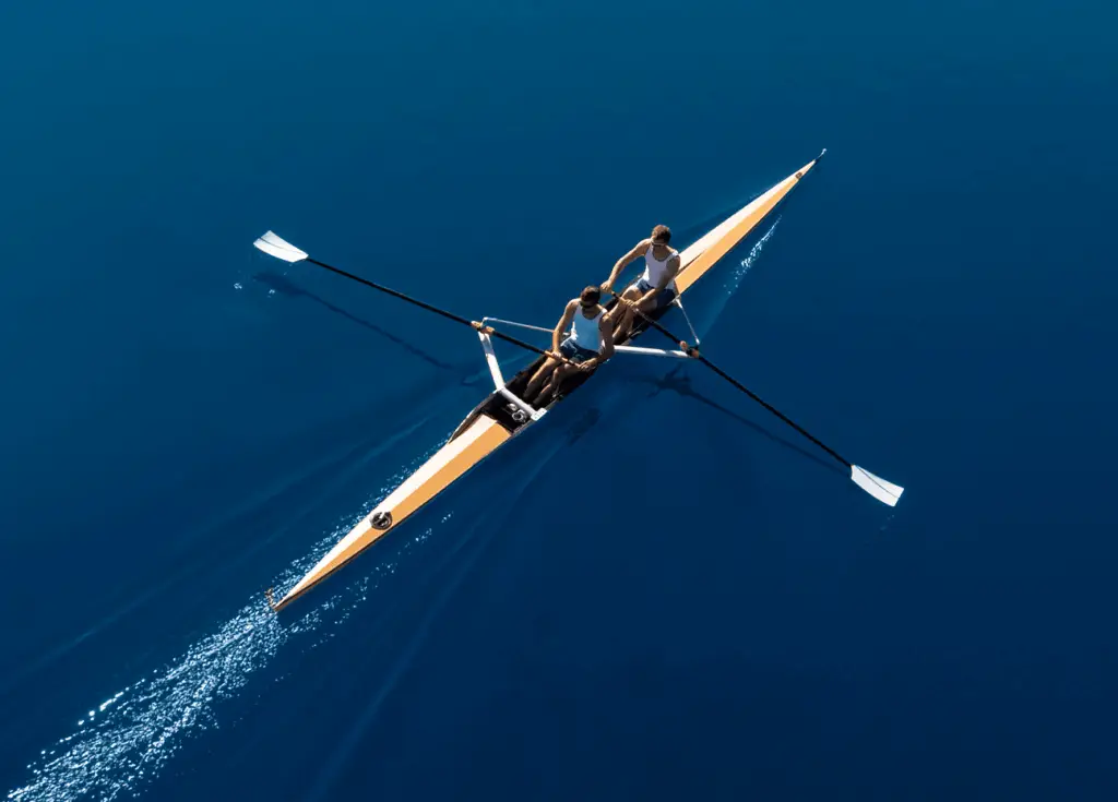 Two rowers moving together across deep blue water